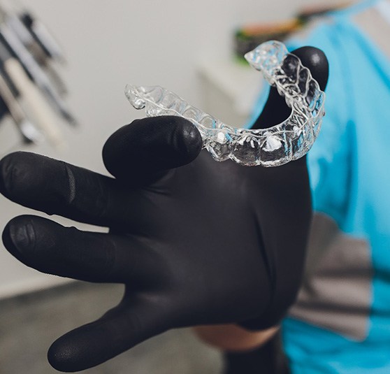 Dentist holding Invisalign aligner