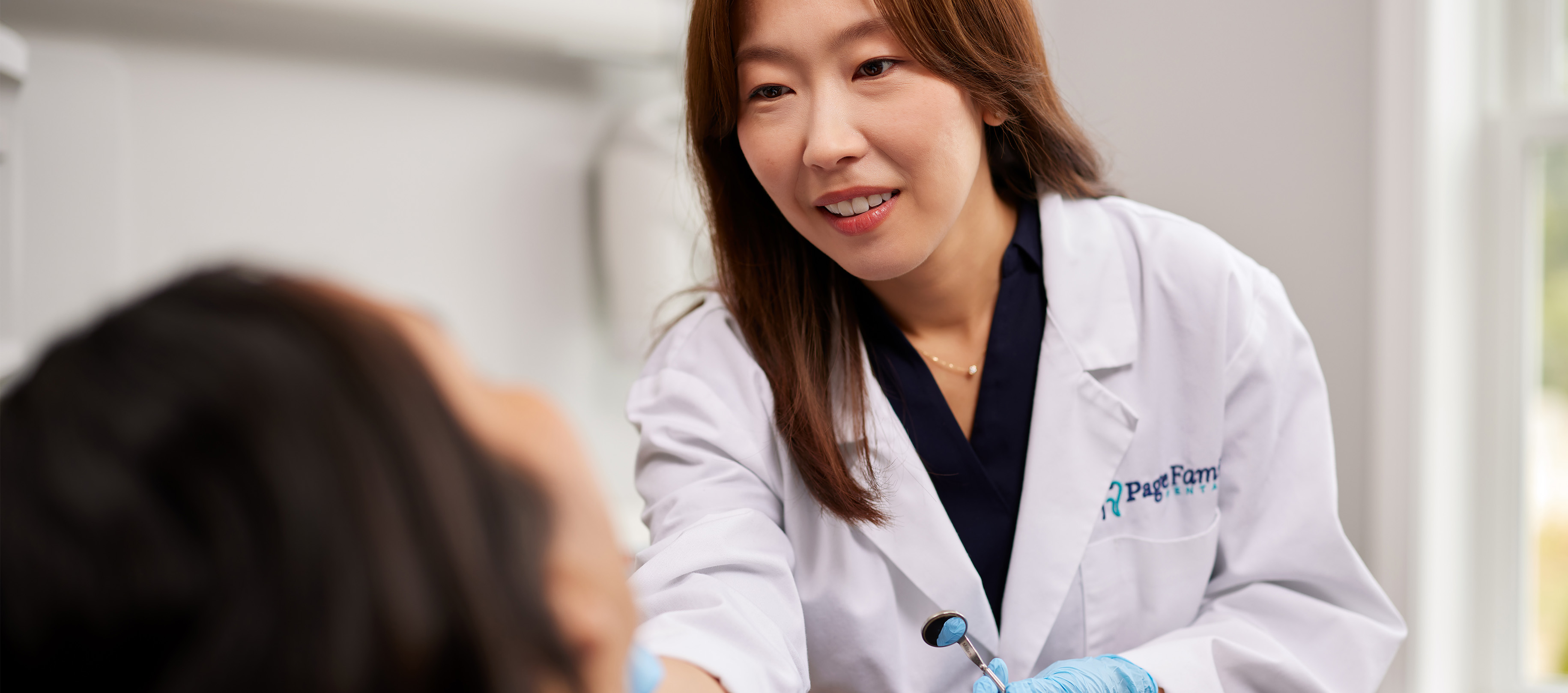 Doctor Ma showing a child dental patient their smile in mirror